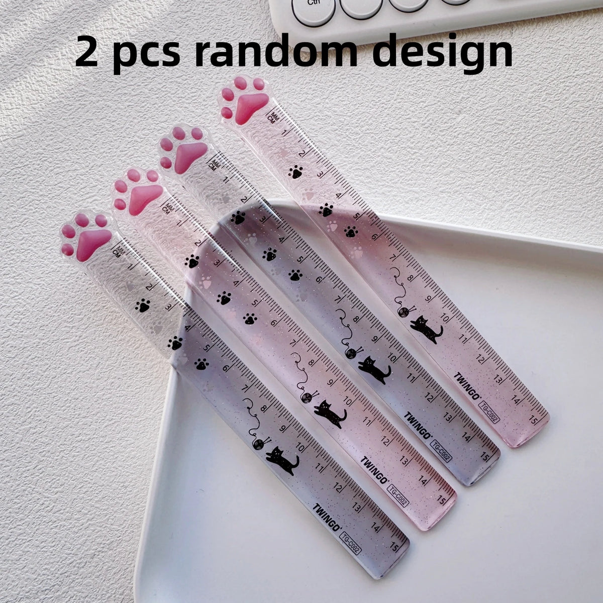 Two pink and purple cat paw design straight rulers for measuring, displayed on a white surface.