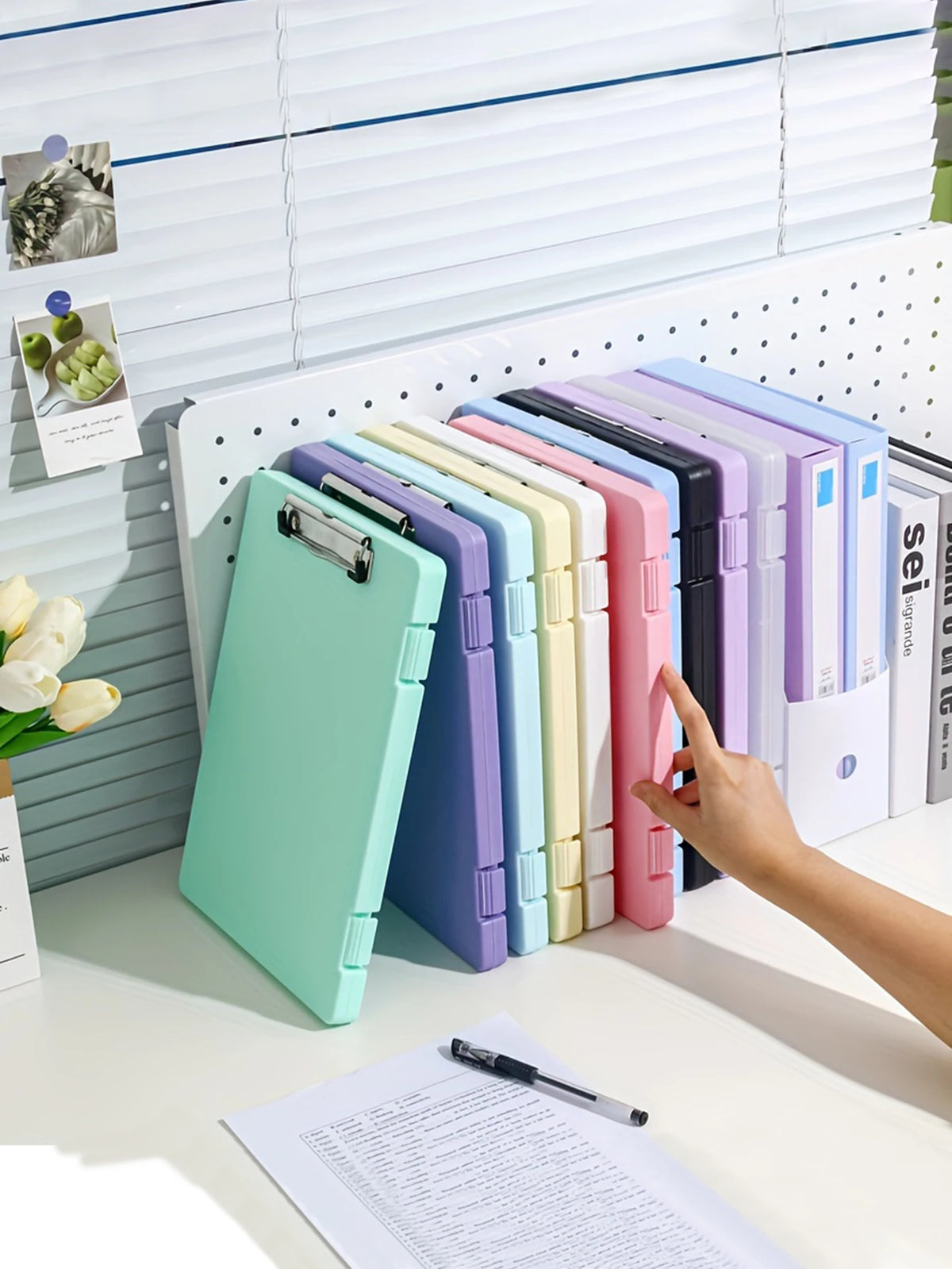 A collection of colorful A4 document and photo storage file boxes lined up on a white desk.