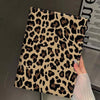 A close-up of a leopard print protective skin for an iPad case being held by a hand.