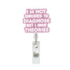 A pink glittery sign with text that reads I'M NOT QUALIFIED TO DIAGNOSE BUT I HAVE THEORIES attached to a clear acrylic badge