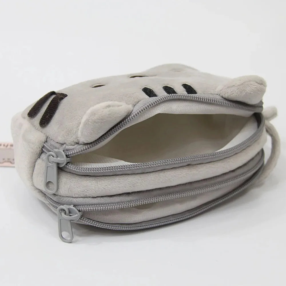 A light gray plush cat pencil case with a zipper opening and multiple zippered compartments.