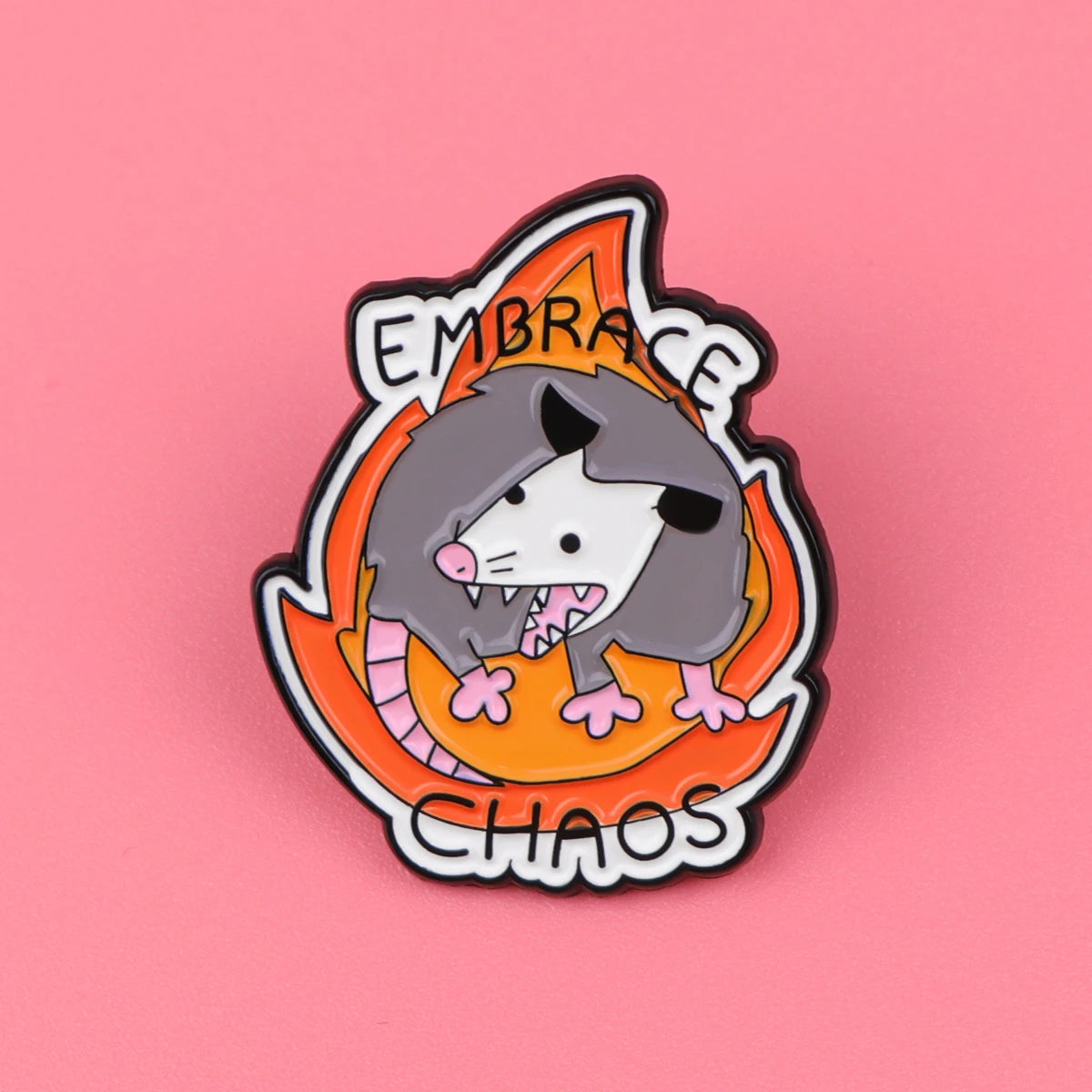 Broche émail représentant une tête de loup stylisée avec des flammes orange lumineuses et le texte Embrace Chaos.