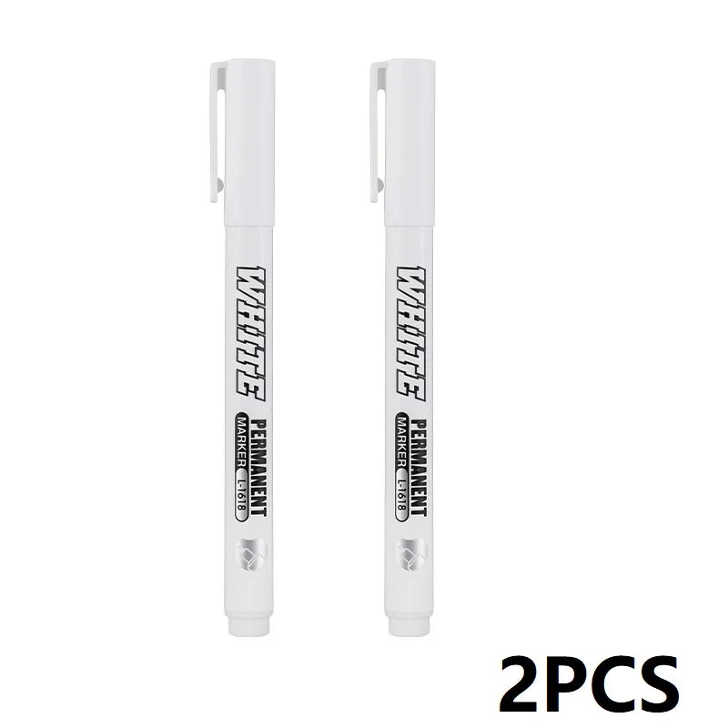 Two white permanent markers with metal tips and plastic bodies shown side by side.