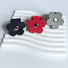 Three leather flower cable organizers in black, red, and gray are displayed on a white wavy surface.