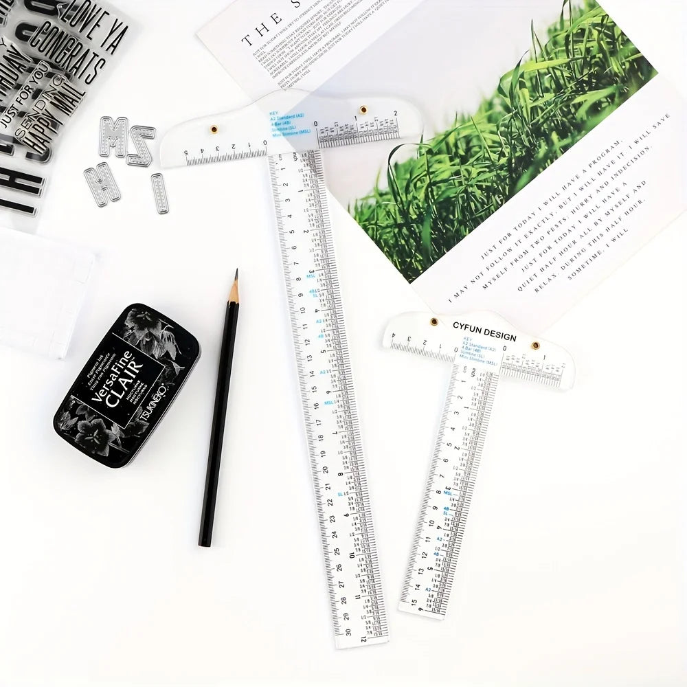 A set of acrylic T-square rulers, including 6 inch and 12 inch versions, are displayed on a white surface next to a pen and p