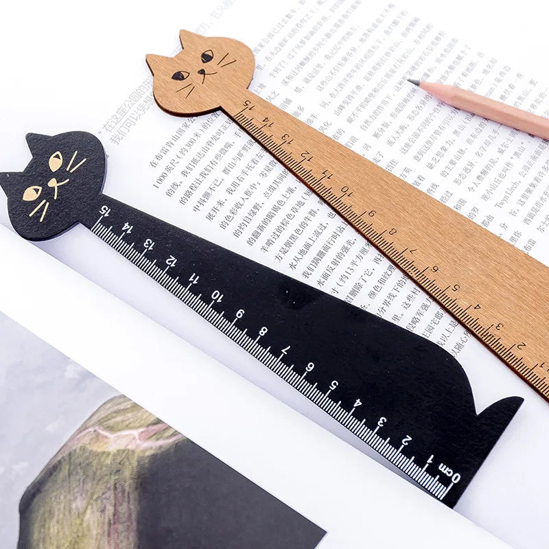 A wooden drawing ruler shaped like a cute cartoon cat is shown on a white background.
