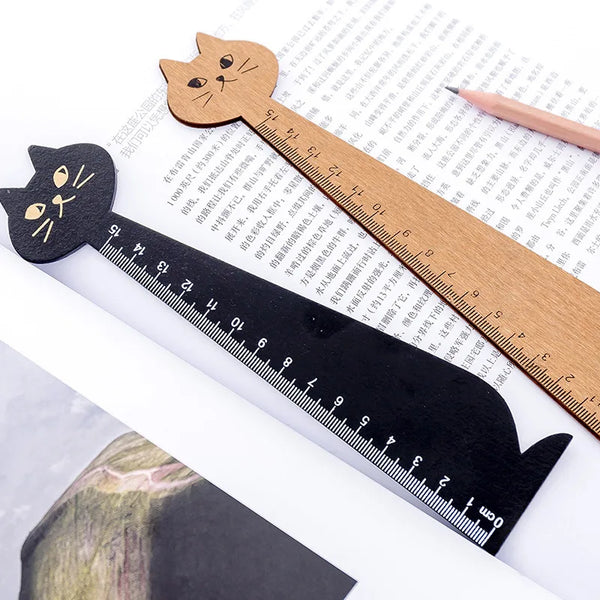 Regla de dibujo de madera con forma de gato caricatura en fondo blanco.