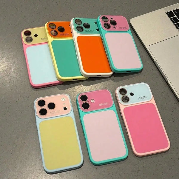 A collection of colorful color block phone cases with full lens protection displayed on a gray surface.