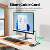 Un cable de 50 cm junto a un monitor y teclado en un escritorio.