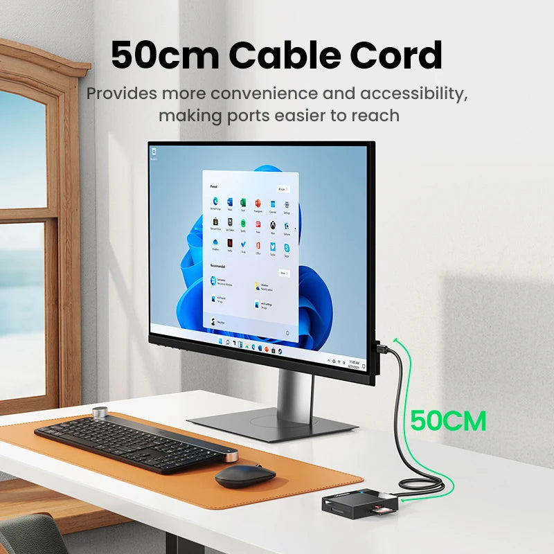 Un cable de 50 cm junto a un monitor y teclado en un escritorio.