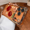 An orange electroplated iPhone case featuring a cherry and leaf pattern, held by a hand.