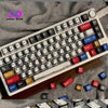 Nahaufnahme einer custom mechanischen Tastatur mit schwarzen Keycaps und farbigen Schaltern auf einer Holzoberfläche.