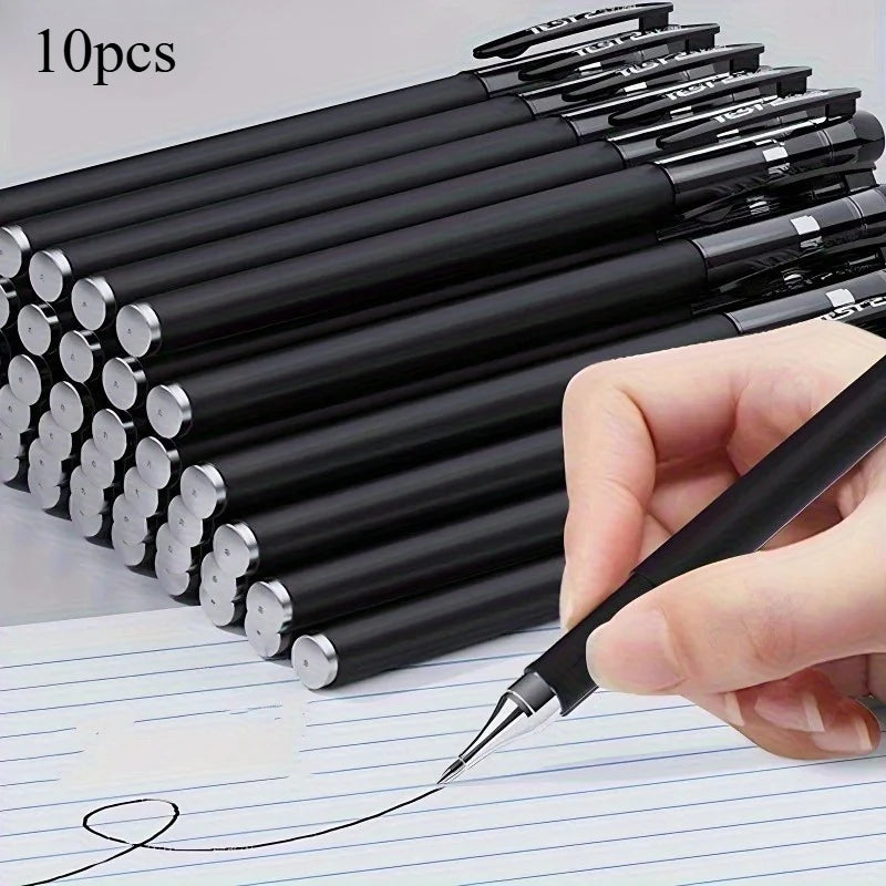 A hand holds a set of 10 black precision gel pens with silver tips resting on lined paper.