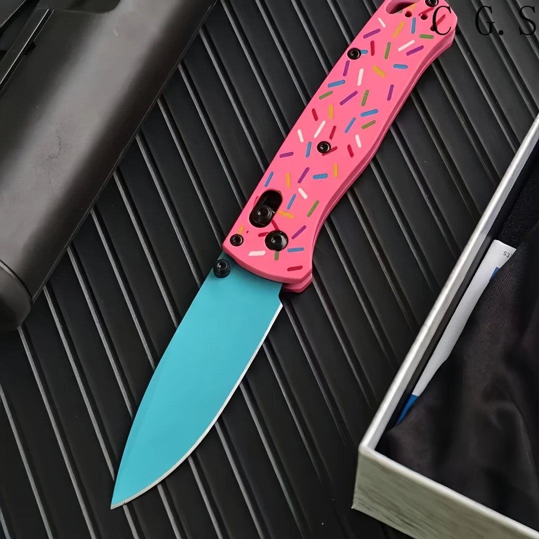 A pink acrylic folding knife with a D2 steel blade is shown resting on a dark surface.