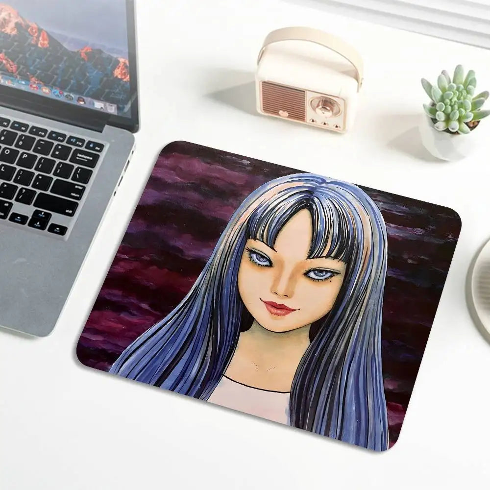 A mouse pad featuring a digital illustration of Tomie from Junji Ito with long blue hair and stitched edges.