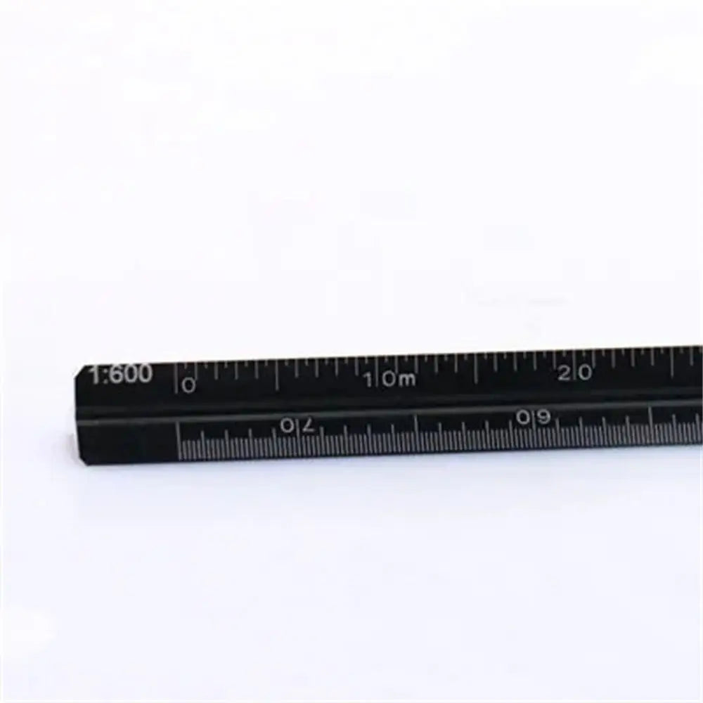 A close-up view of a black aluminum triangular scale ruler with metric markings.
