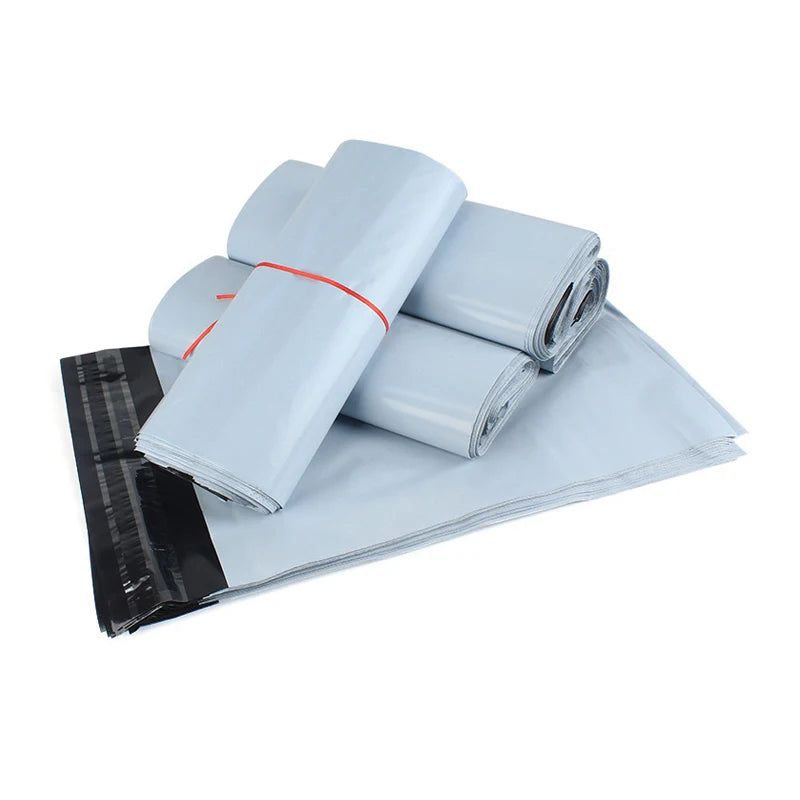 A stack of light blue self-adhesive courier mailer bags with orange tape on the seam.