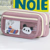 A pink pencil case with a transparent flip pocket featuring a panda charm.
