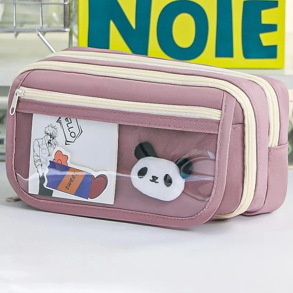 A pink pencil case with a transparent flip pocket featuring a panda charm.