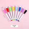 An assorted set of eight dry erase markers with magnetic erasers in various colors arranged on a pink background.