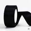 A roll of black satin ribbon used for gift wrapping and DIY crafts.
