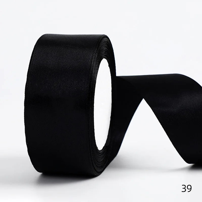 A roll of black satin ribbon used for gift wrapping and DIY crafts.