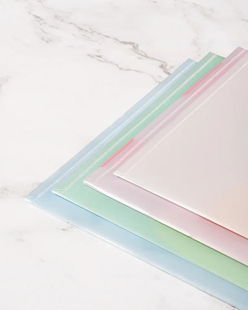 A set of four transparent document pouches in pastel colors, including pink, mint green, and light blue, laid diagonally on a