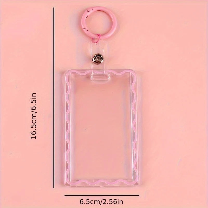 A clear pink acrylic card holder with a pink key ring and a metal loop, shown against a light pink background.