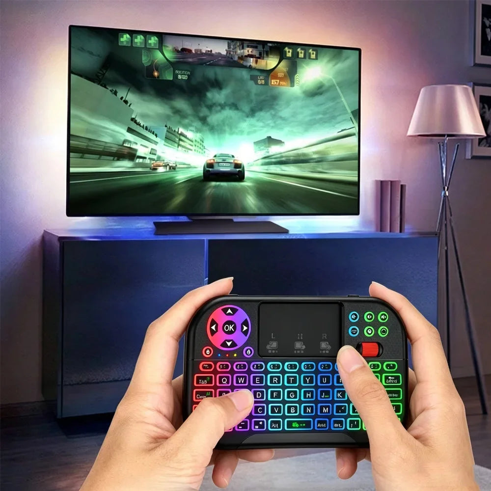 يد تمسك بلوحة مفاتيح وماوس لاسلكية سوداء مزدوجة النمط RGB أمام شاشة كمبيوتر.