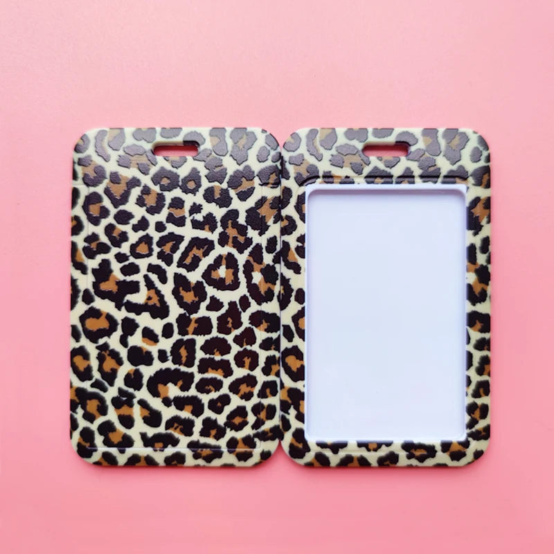 A pair of leopard print ID holders or keychains displayed against a pink background.