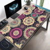 A vintage Persian rug patterned gaming mouse pad with a non-slip rubber base placed on a wooden desk.