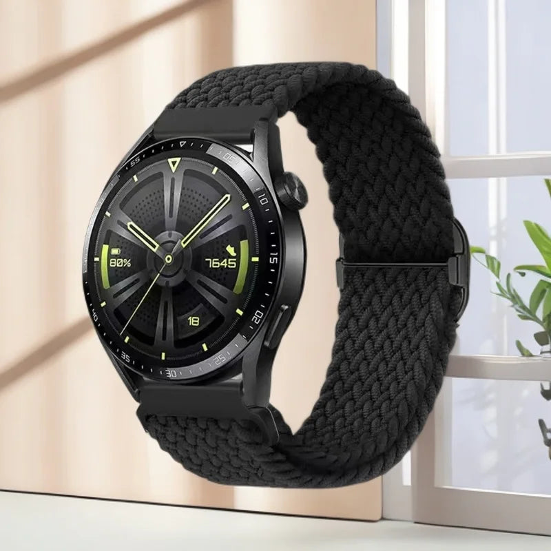 A black nylon watch strap with a digital watch face is displayed next to a window.