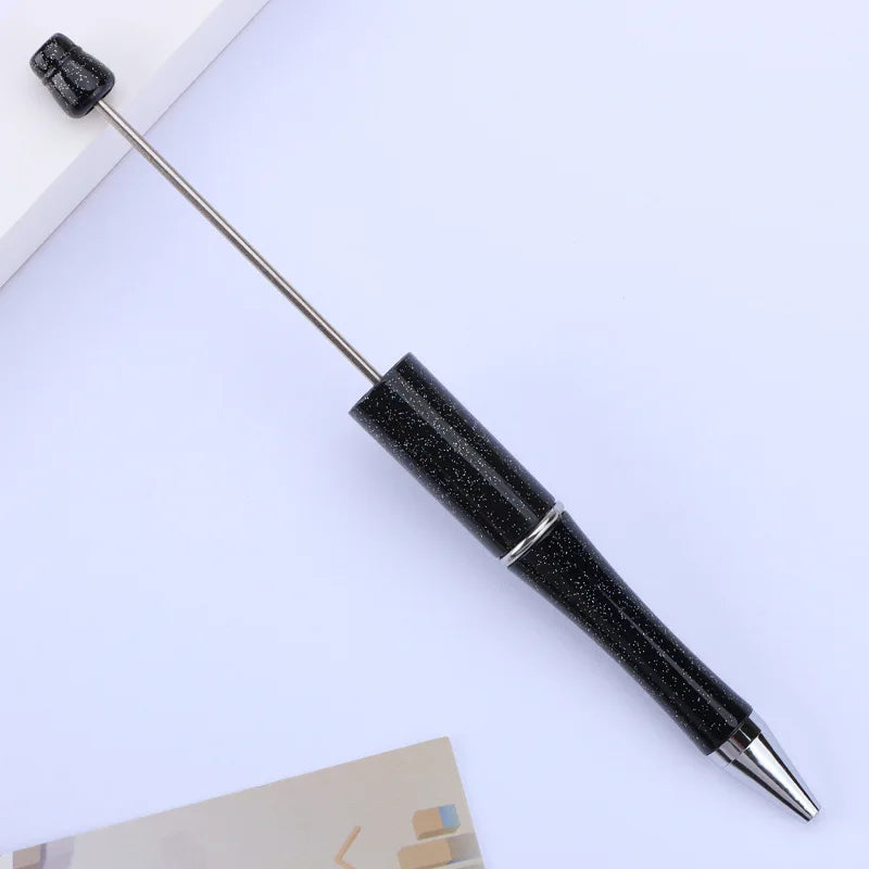 A black DIY beadable pen with a silver tip is shown on a white background.