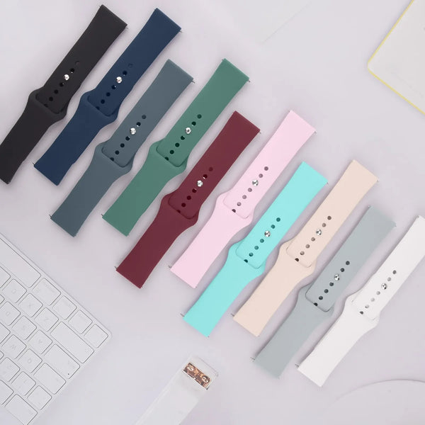 A collection of silicone quick release watch bands in various colors laid out on a white surface.