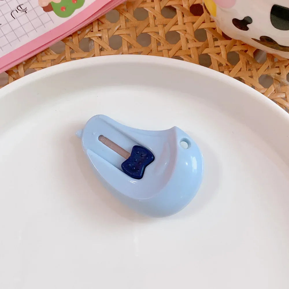 A small, light blue cat paw-shaped mini cutter is placed on a white plate.