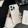 A hand holds a silver glossy tempered glass shockproof case for an iPhone against a dark background.