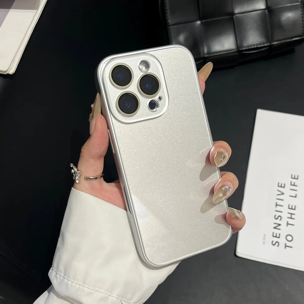 A hand holds a silver glossy tempered glass shockproof case for an iPhone against a dark background.