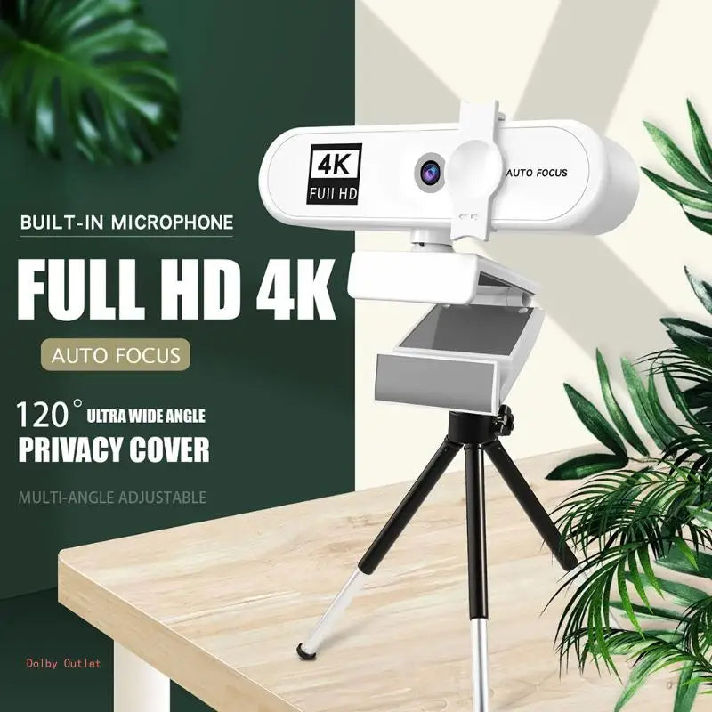 Webcam 4K HD autofocus blanche montée sur trépied, sur fond de plante verte floutée.