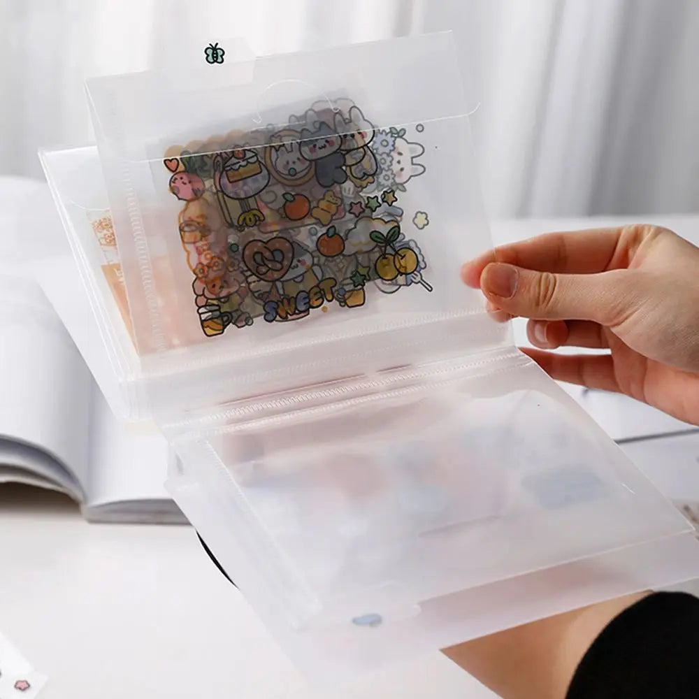A hand holds open a transparent storage book filled with stickers and documents.