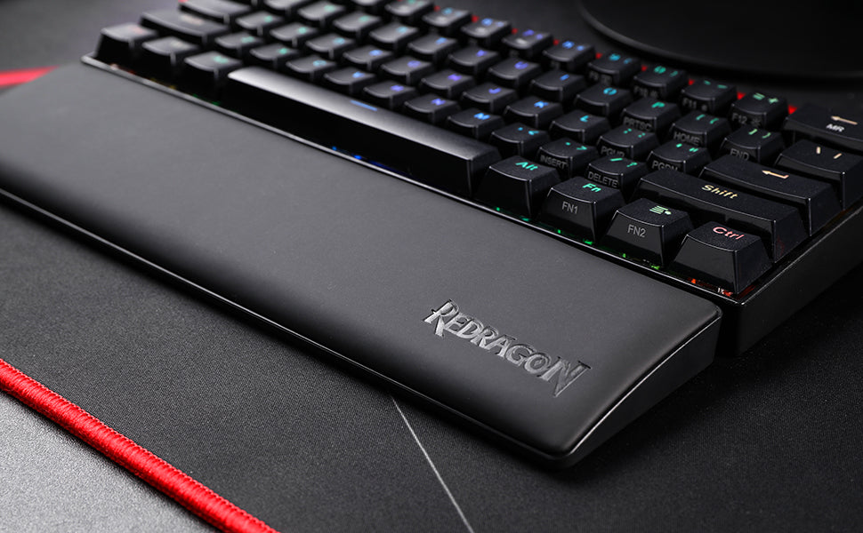 A black ergonomic memory foam keyboard wrist rest with an anti-slip base is shown on a dark surface.