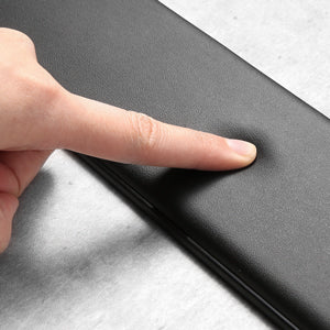 A hand is pressing on a black ergonomic memory foam keyboard wrist rest with an anti-slip base.